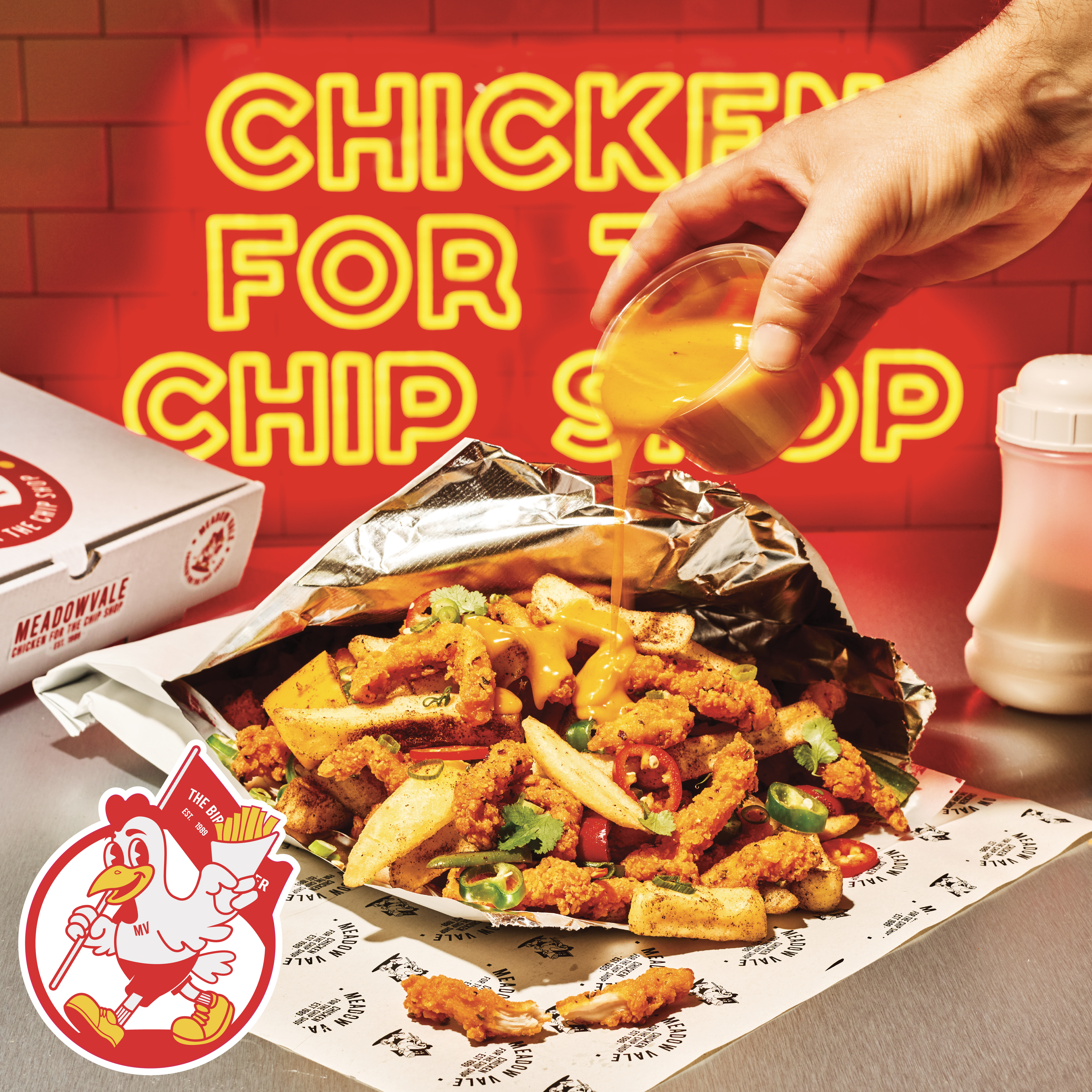 curry sauce being drizzled on chicken and chips